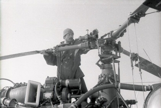 Sur le pont du Thala Dan, sous la neige, l'un des membres du détachement "hélico" installent le rotor de leur machine.