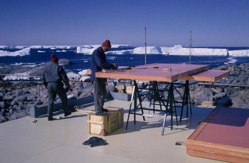 Construction du nouveau bâtiment "séjour". Préparation des panneaux de fermeture ou de couverture "Spair". Au loin, nombreux grands icebergs.