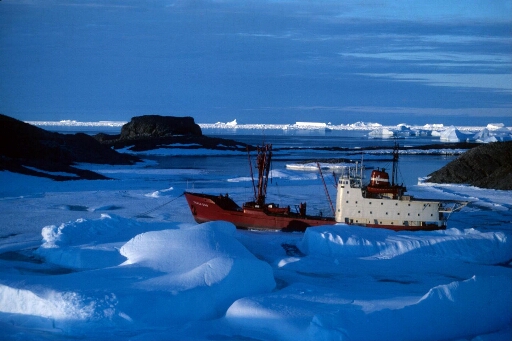 Vue prise au couchant : le Thala Dan au mouillage dans l'archipel au milieu d'un chaos de glace. Icebergs à l'horizon.