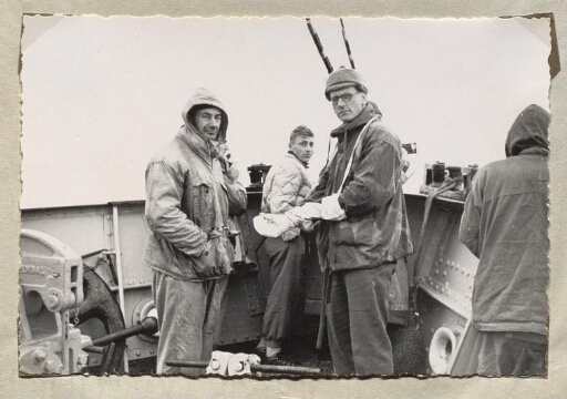 Trois Hommes à la proue du navire Lyngen regardent le photographe